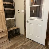 Boot room detail with bench, coat rack, and door with window