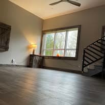 Studio corner with staircase, modern metal railing, bench, and window